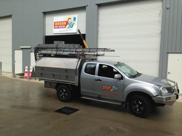 A silver service truck branded with the Hogan Hot Water logo