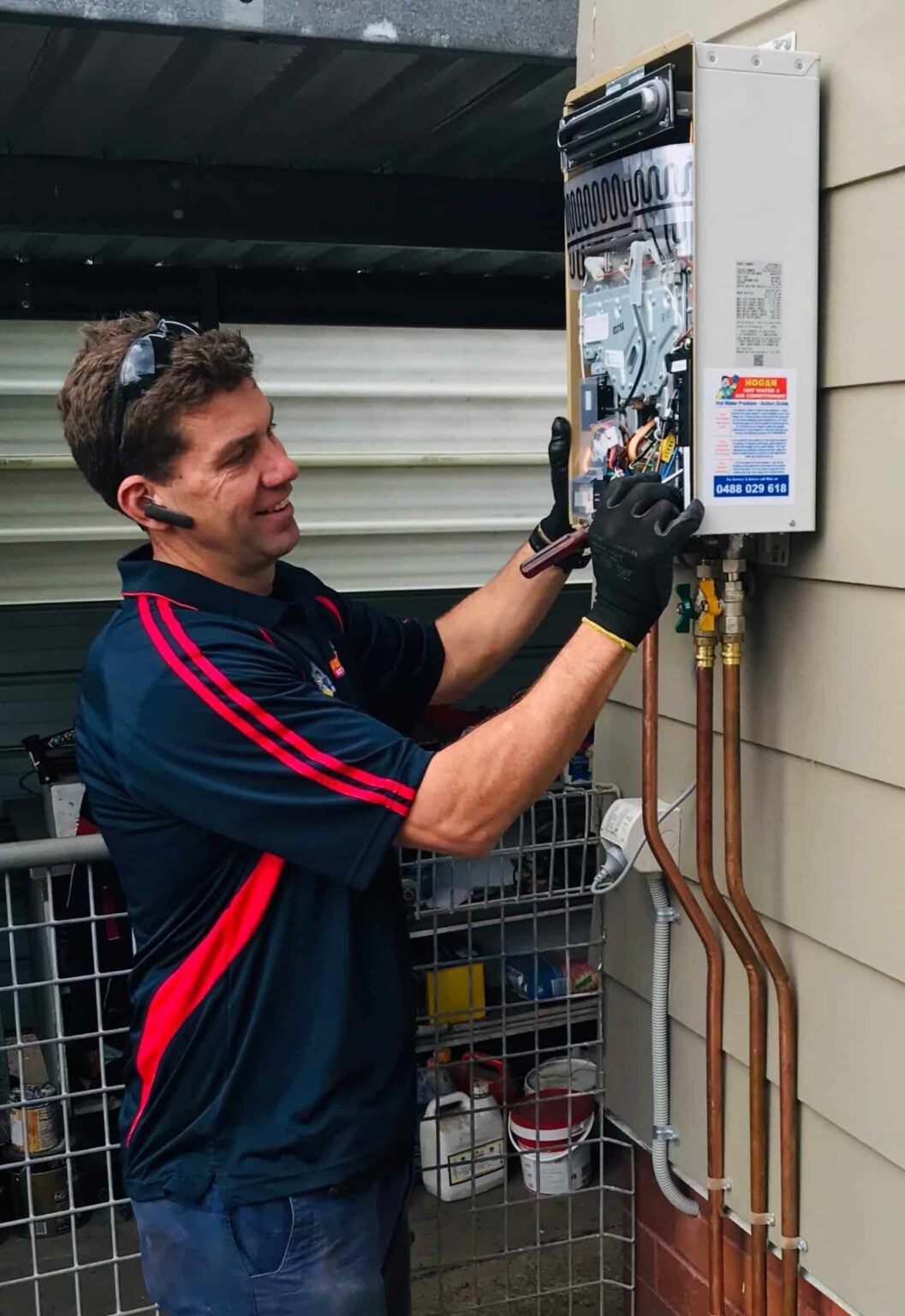 Home » Hot water system Licensed technician servicing a Rheem Metro continuous flow gas hot water system installed outside a home in Newcastle, NSW