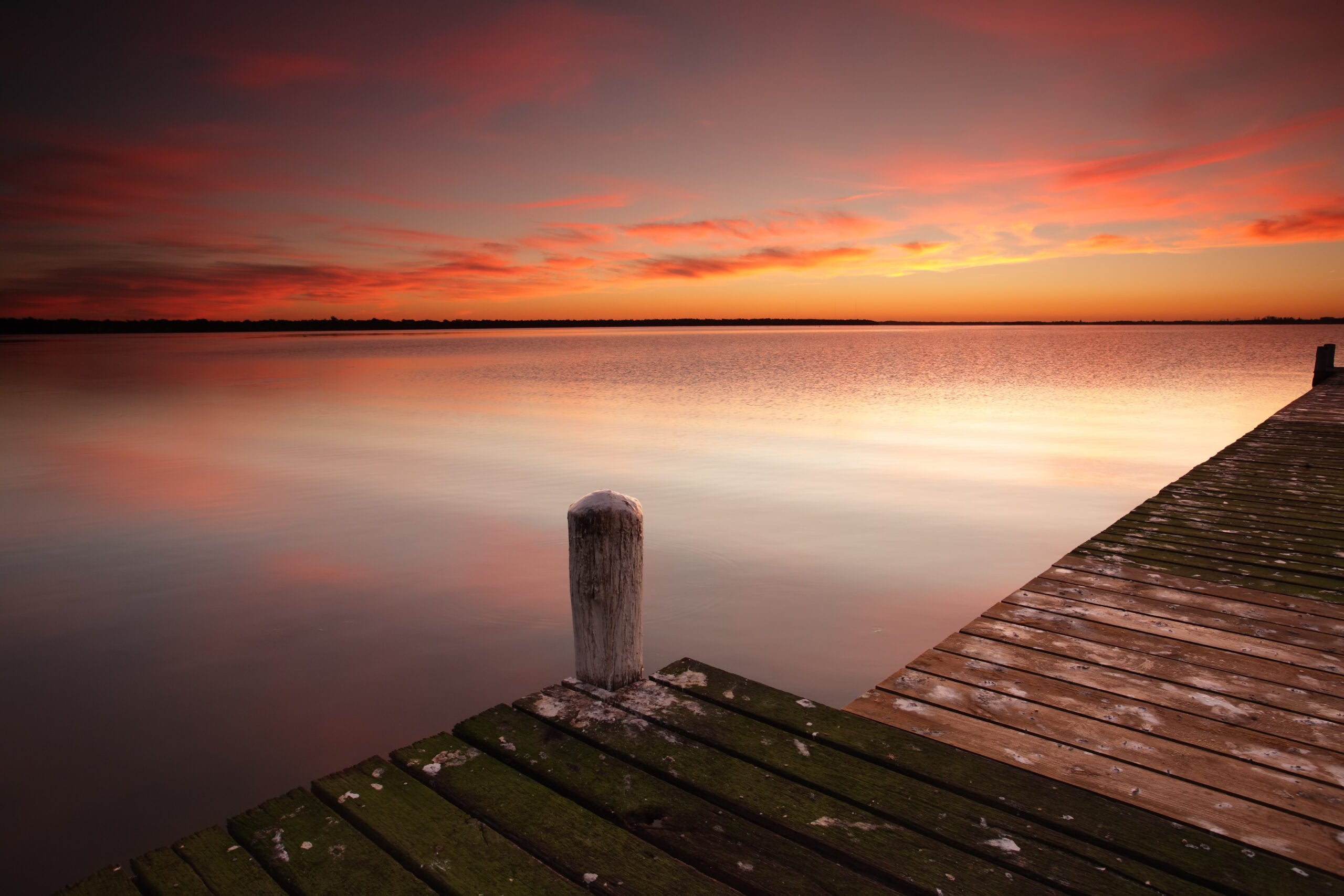 A wooden jetty corner with a single mooring