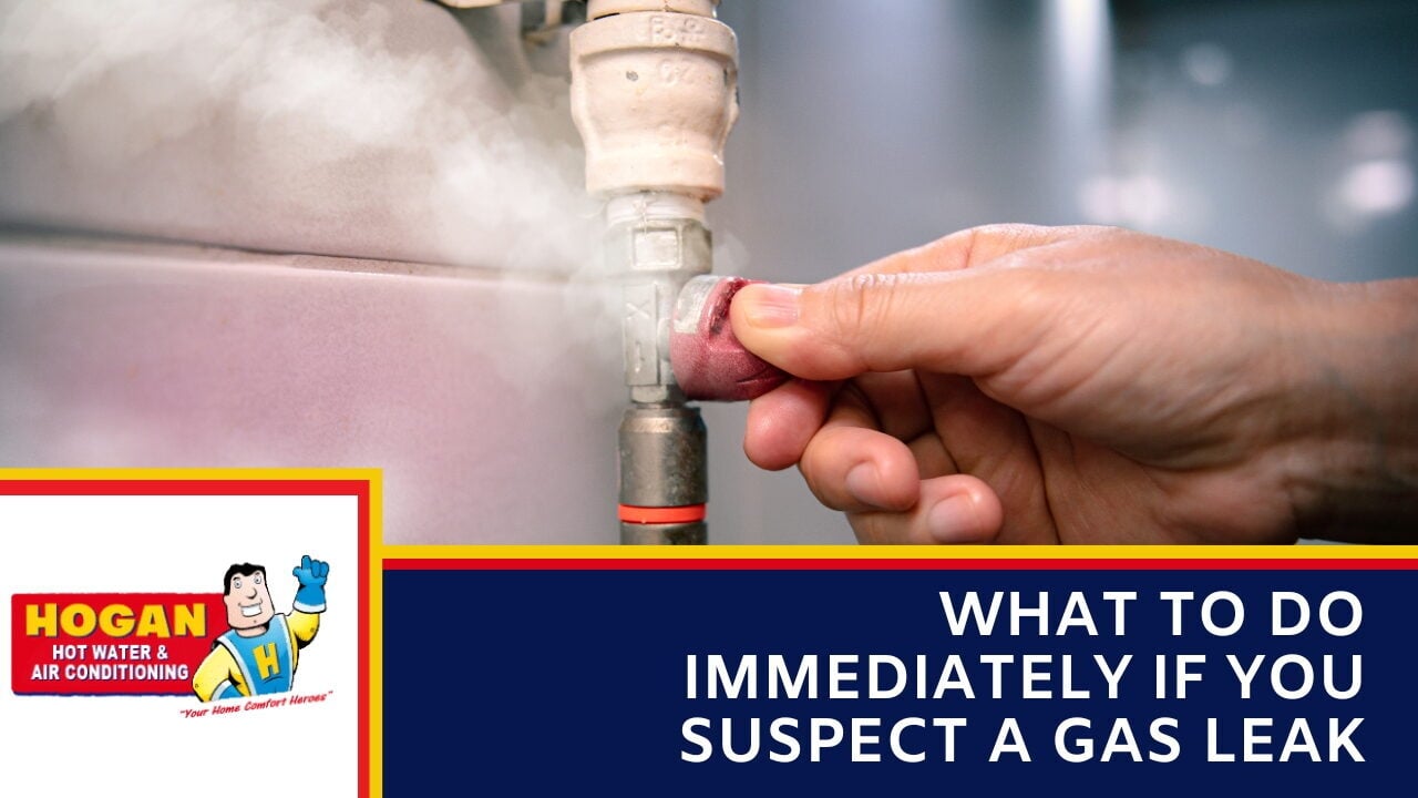 A hand turning a red valve on a gas line with white vapor or smoke leaking nearby.
