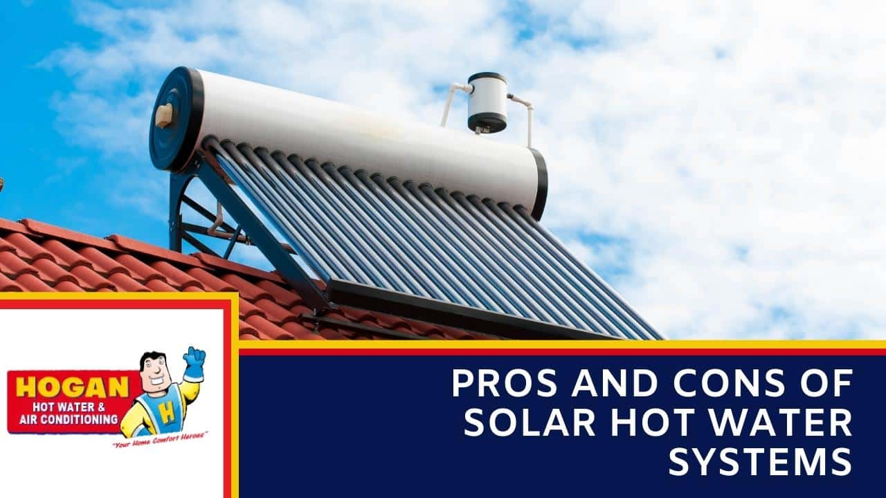 An evacuated tube solar collector and a white storage tank installed on a red tiled roof