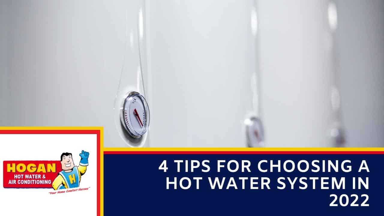 A row of white hot water storage tanks with focus on a circular temperature gauge with a red needle.
