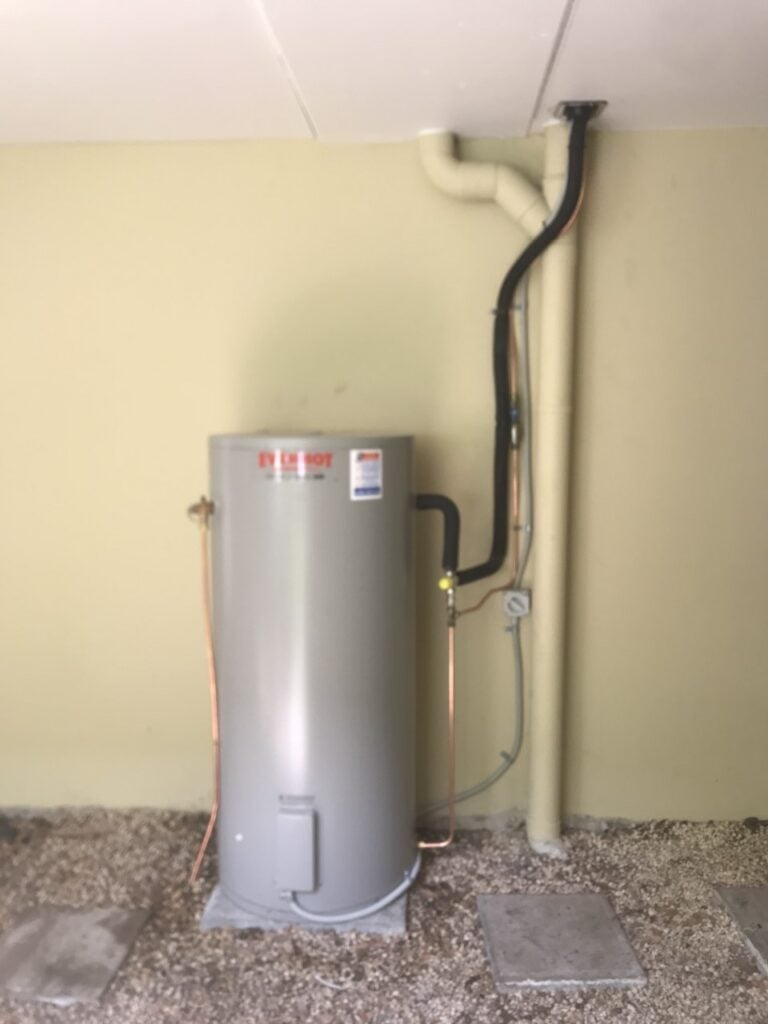 An Everhot electric storage hot water system professionally installed on a concrete base in an under-house or crawl space area.