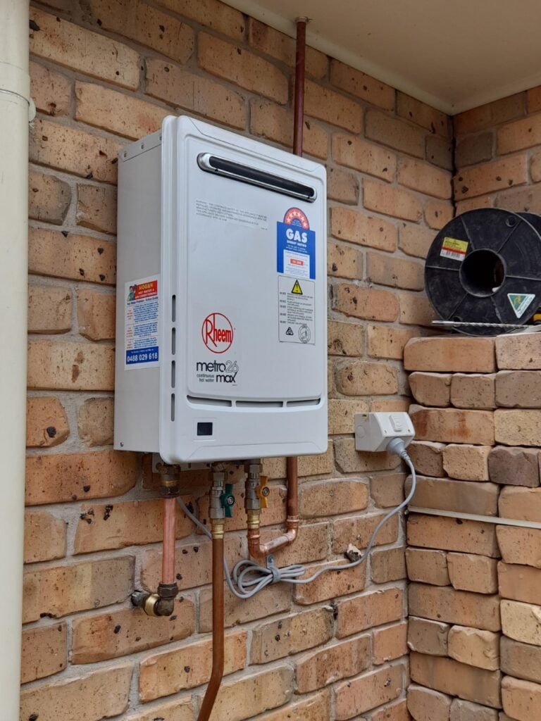 Rheem Metro 26 Max continuous flow gas hot water system delivering 26 litres per minute, installed on a brick wall of a residential home in Newcastle, NSW