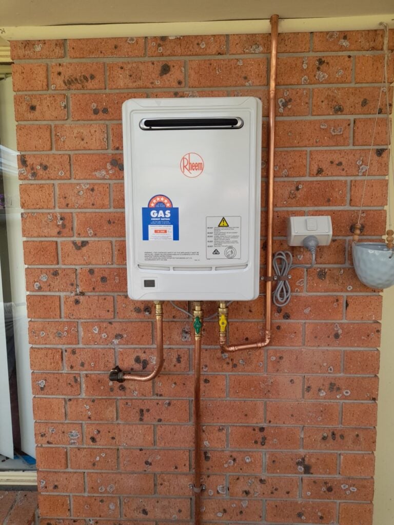 Rheem Metro continuous flow natural gas hot water system installed on an exterior brick wall of a home in Newcastle, NSW
