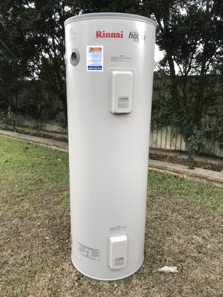 A Rinnai Hotflo electric water heater standing on a grassy lawn outdoors.