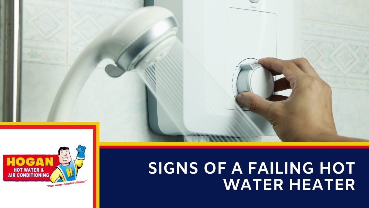 A hand adjusting the dial on an electric shower unit while water runs from the showerhead