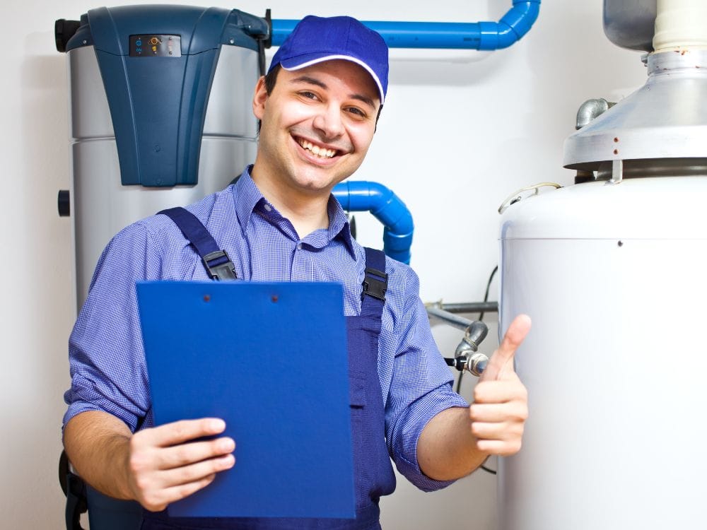 A smiling technician holding a blue clipboard while giving a thumbs-up sign.