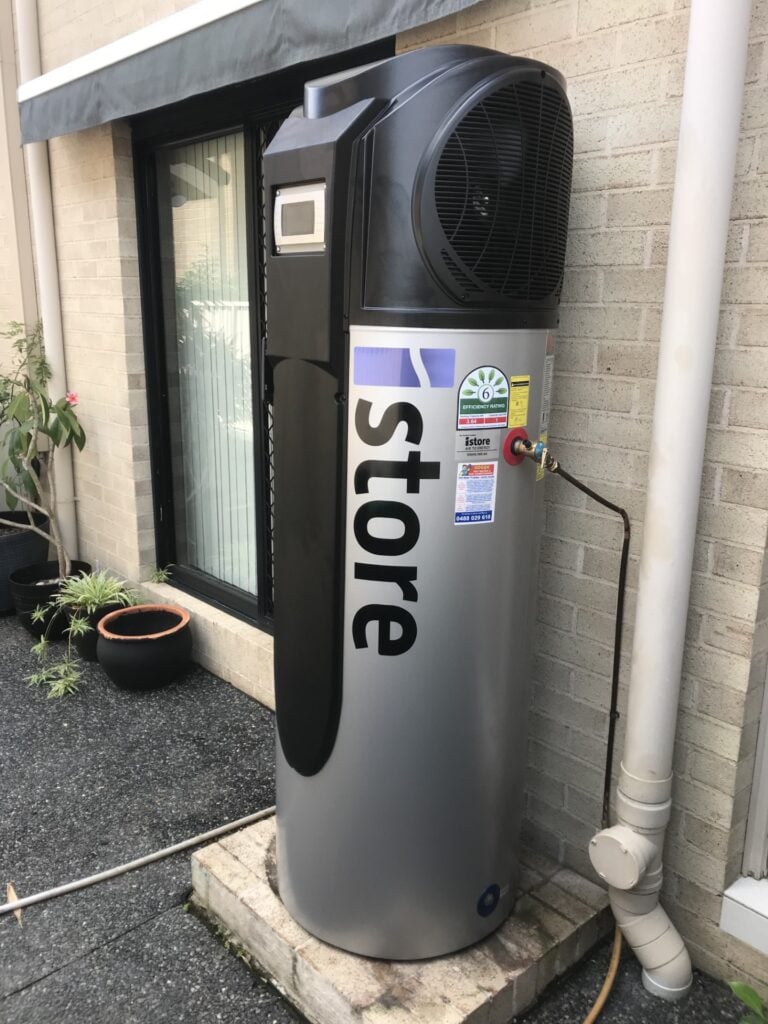 A silver iStore heat pump water heater with a black top fan unit.