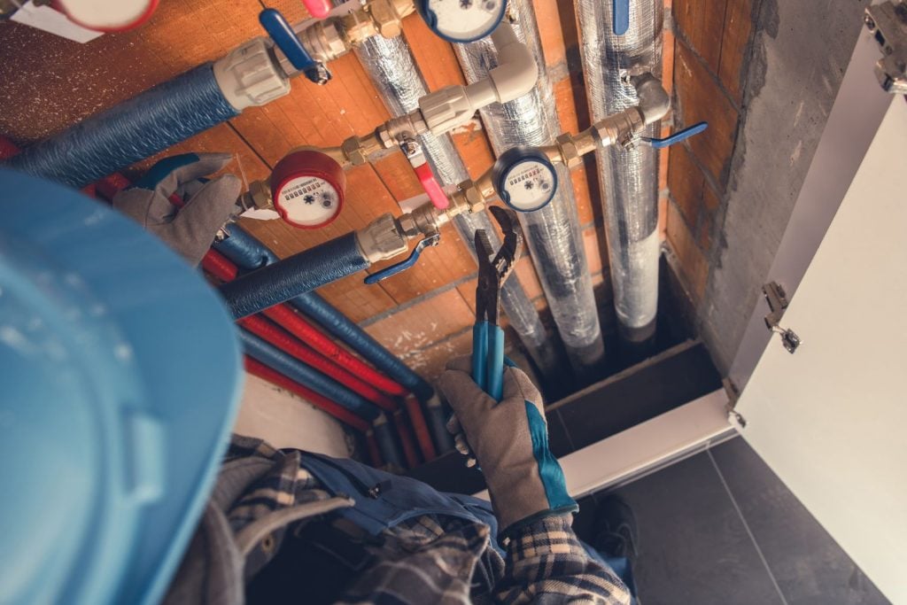 An overhead view of a technician wearing a blue hard hat and work gloves.