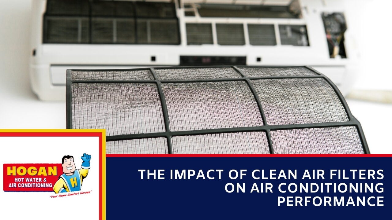 A dirty air conditioner filter being held up in front of a white air conditioning unit.