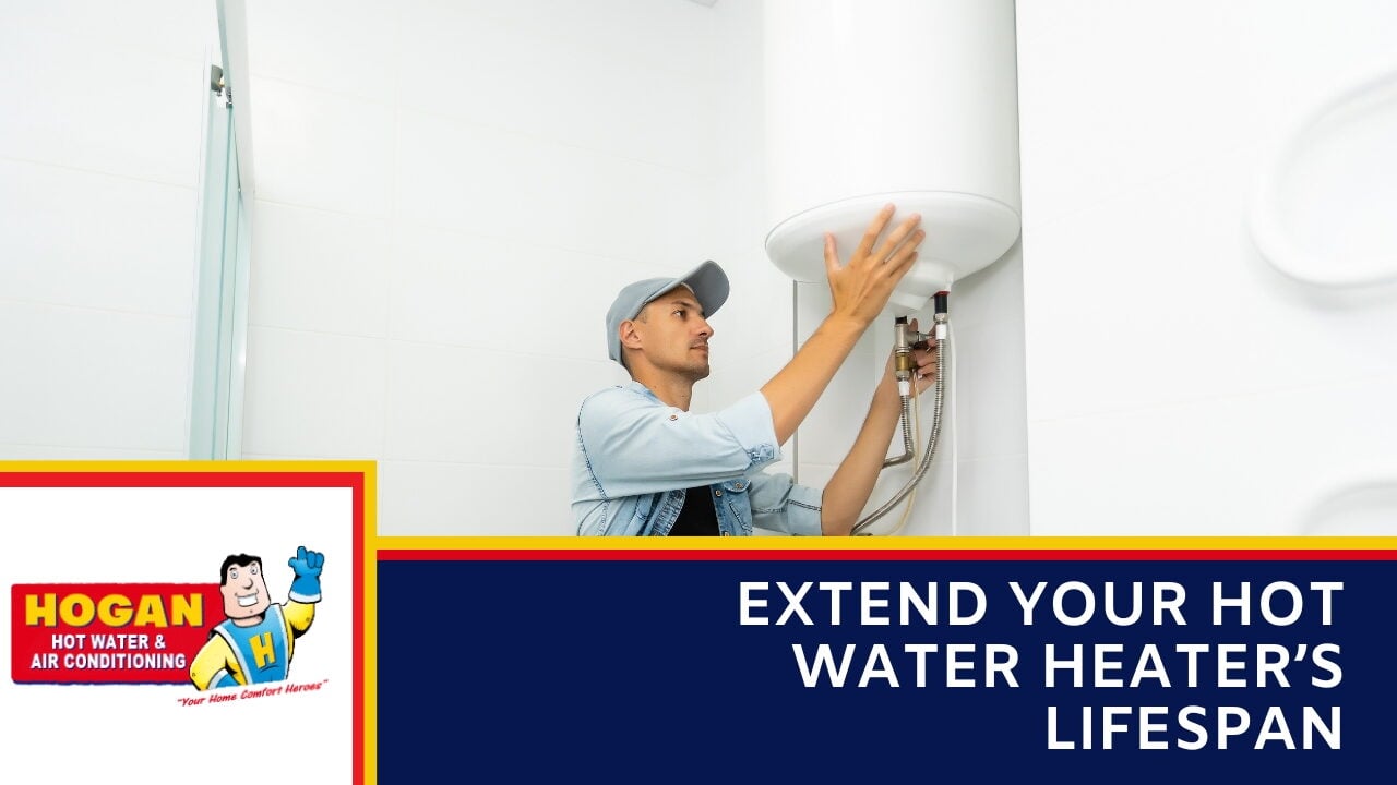 A technician in a light blue shirt and cap inspecting a white wall-mounted water heater.