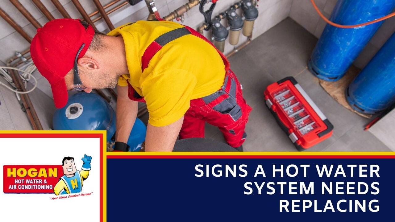 A technician in a red cap and yellow and red workwear servicing utility equipment on a tiled floor near a toolbox.