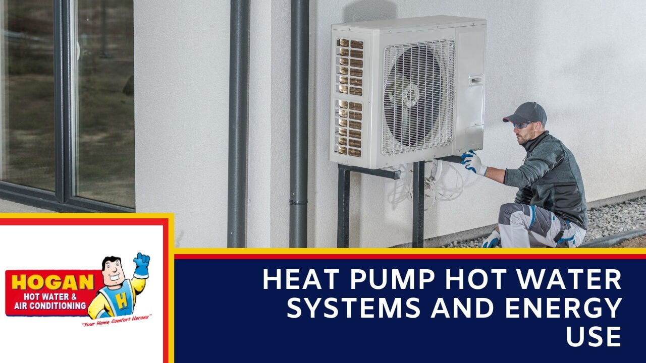 A technician kneeling to inspect a wall-mounted outdoor heat pump compressor next to a building wall.