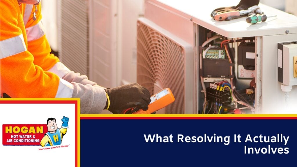 A close-up of an Aircon technician's gloved hands using a multimeter to test the internal wiring of an air conditioning unit