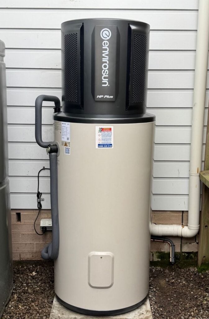 Envirosun HP Plus heat pump hot water system installed outdoors against weatherboard siding.