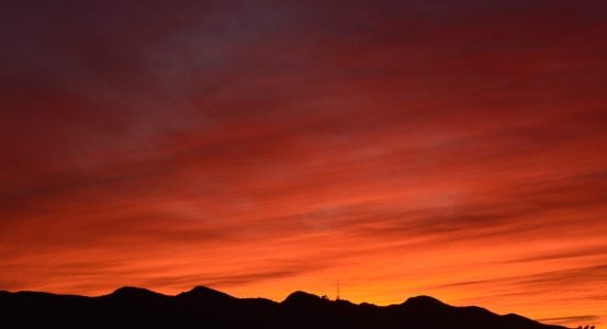 Hot Water Installation and Maintenance Glendale A silhouette of a mountain range against a vibrant sunset