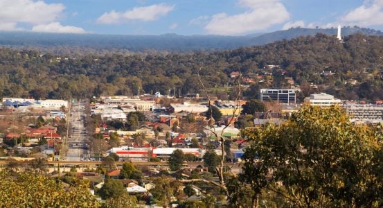 Hot Water Installation and Maintenance Lambton Aerial view of a coastal town surrounded by lush forest, winding waterways, and mountains in the background.