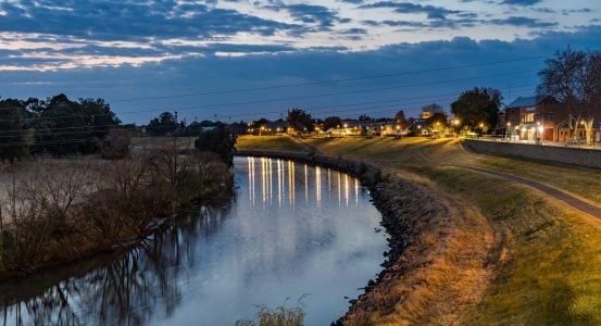 A tranquil evening view of a river winding through a town in Australia.