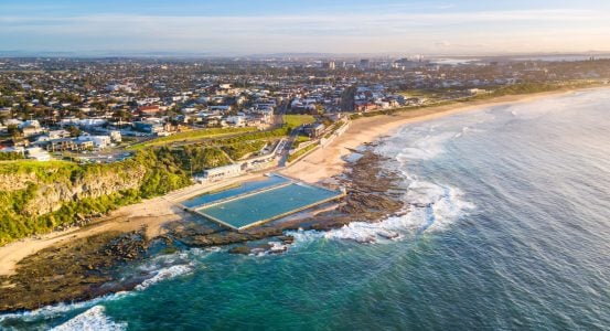 A coastal city featuring a large ocean pool built into the rocky shoreline of Merewether
